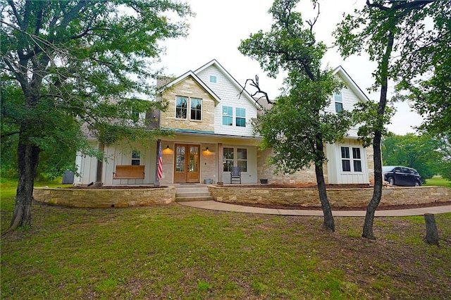 view of front of property featuring a front yard, french doors, and a porch