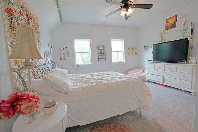 bedroom with carpet floors, vaulted ceiling, ceiling fan, and ornamental molding