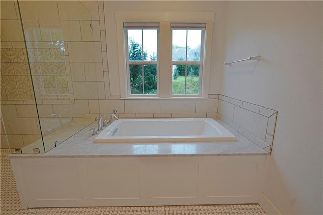 bathroom featuring tiled tub and tile patterned flooring