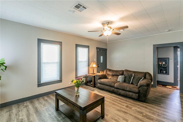 living room featuring light hardwood / wood-style flooring and ceiling fan