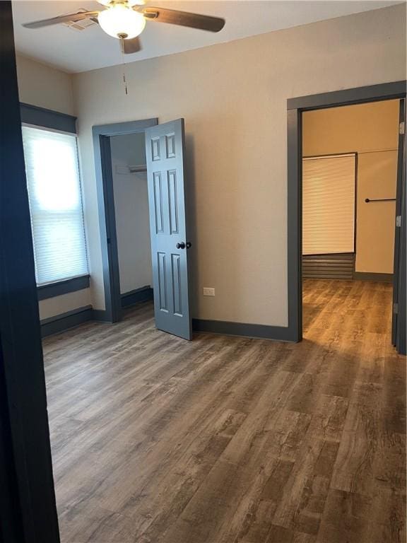 unfurnished bedroom with dark hardwood / wood-style flooring, a closet, and ceiling fan