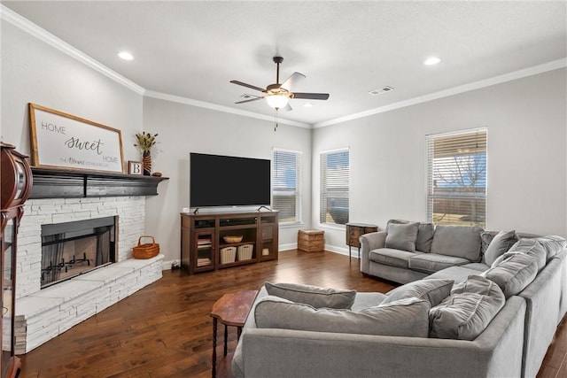 living room featuring hardwood / wood-style floors, visible vents, a fireplace, ceiling fan, and crown molding