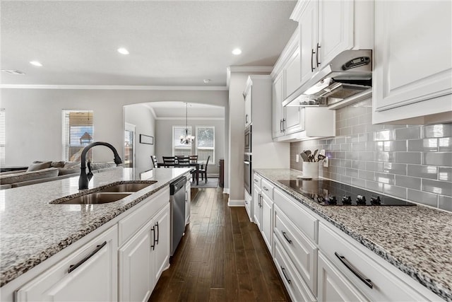 kitchen with arched walkways, stainless steel appliances, a sink, white cabinets, and under cabinet range hood