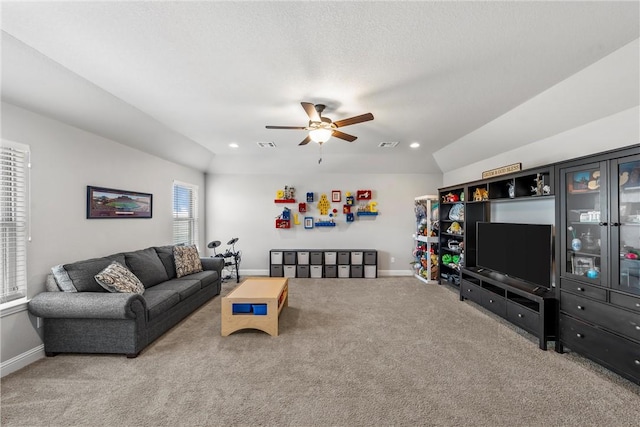 living room featuring vaulted ceiling, visible vents, baseboards, and carpet floors