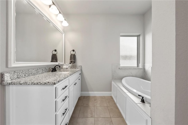 full bathroom with baseboards, a bath, vanity, and tile patterned flooring