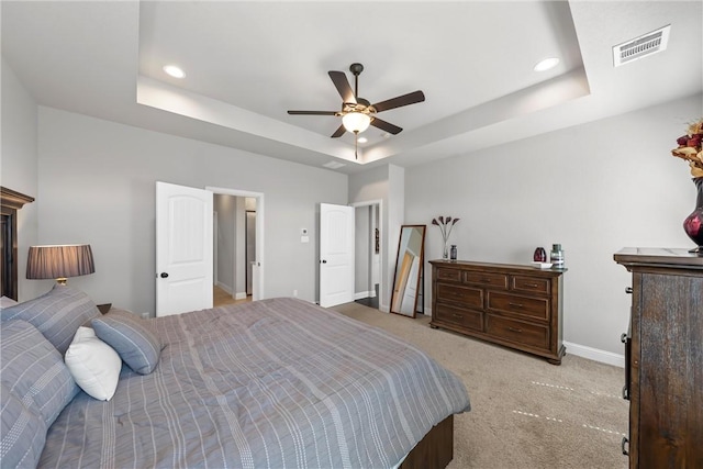 bedroom with visible vents, baseboards, light colored carpet, recessed lighting, and a raised ceiling