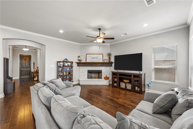 living area featuring visible vents, arched walkways, wood-type flooring, and a fireplace