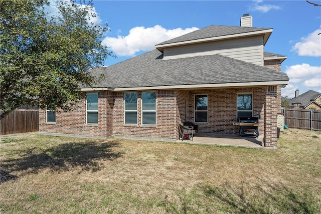 back of property with brick siding, a lawn, and a fenced backyard