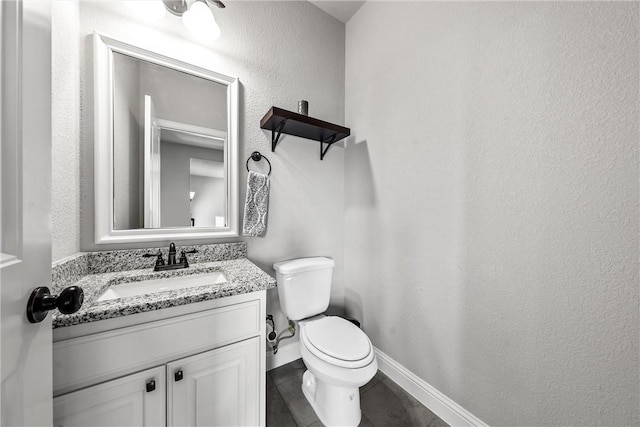 half bath featuring toilet, tile patterned flooring, baseboards, vanity, and a textured wall