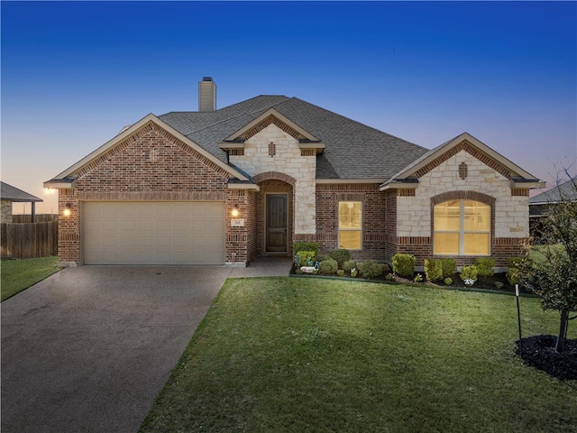 french provincial home featuring a front lawn, concrete driveway, an attached garage, a shingled roof, and a chimney