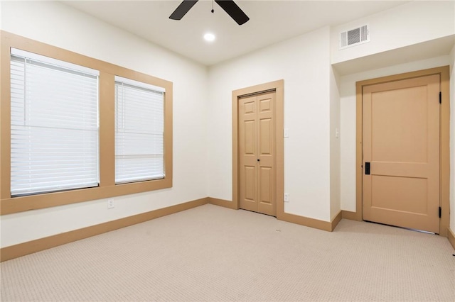 unfurnished bedroom featuring ceiling fan, light carpet, and a closet