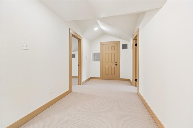 hall featuring vaulted ceiling and light colored carpet