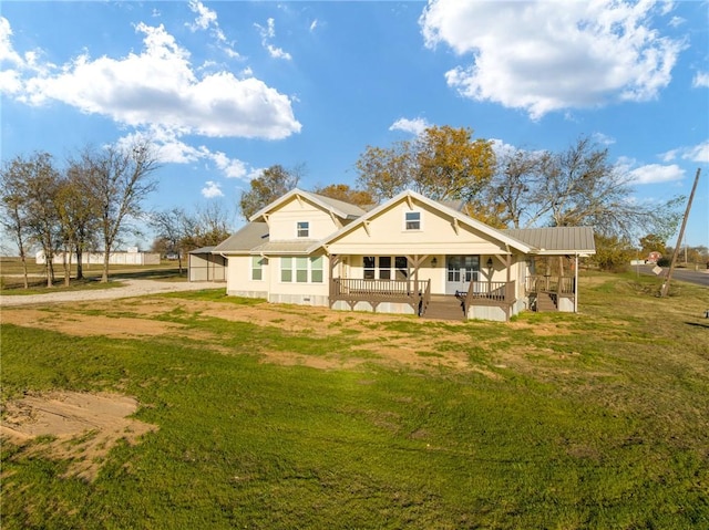 rear view of property with covered porch and a yard