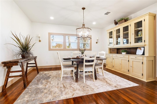 dining room with an inviting chandelier and dark hardwood / wood-style floors