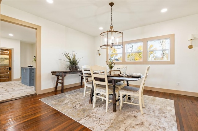 dining area featuring hardwood / wood-style floors and an inviting chandelier