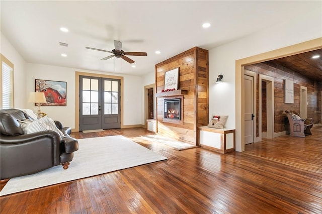 living room with french doors, ceiling fan, hardwood / wood-style flooring, and a fireplace