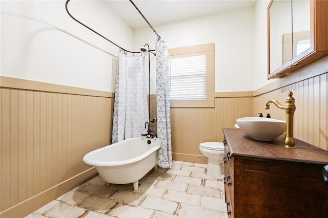 full bathroom featuring toilet, shower / bath combination with curtain, and vanity