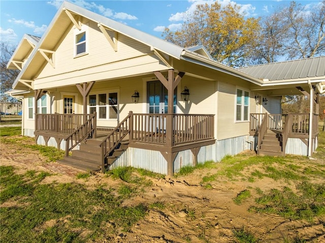 rear view of property featuring covered porch