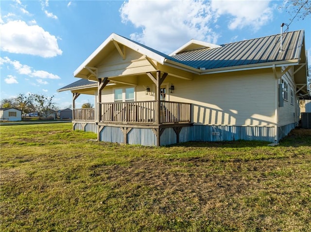 rear view of house featuring central AC and a yard