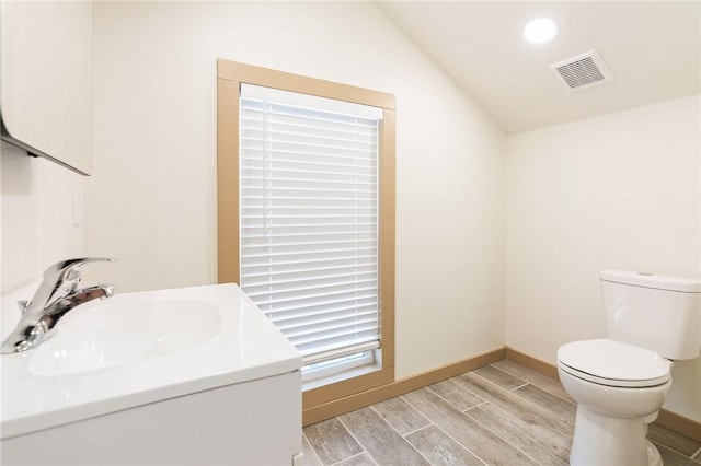 bathroom with vaulted ceiling, sink, and toilet