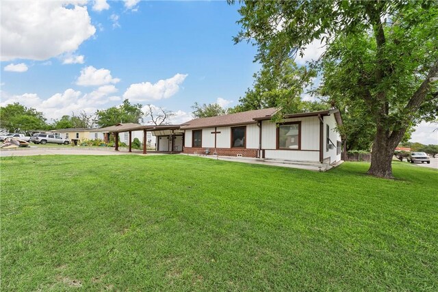 view of front of property featuring a front lawn and a carport