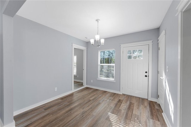 entryway with dark hardwood / wood-style flooring and an inviting chandelier