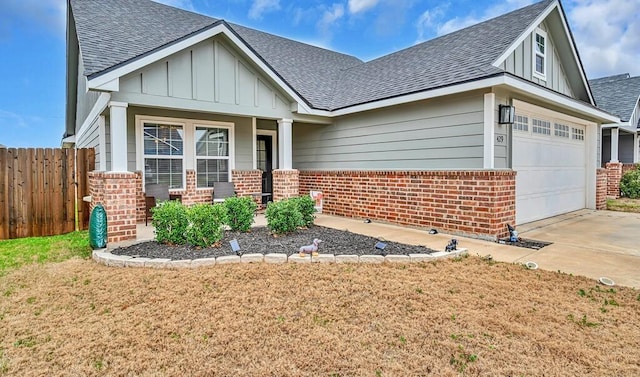 view of front of house featuring board and batten siding, brick siding, and fence