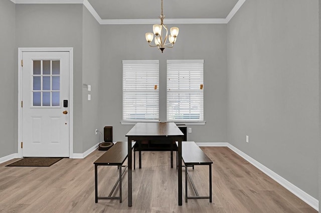 dining area featuring ornamental molding, a notable chandelier, light wood-style flooring, and baseboards