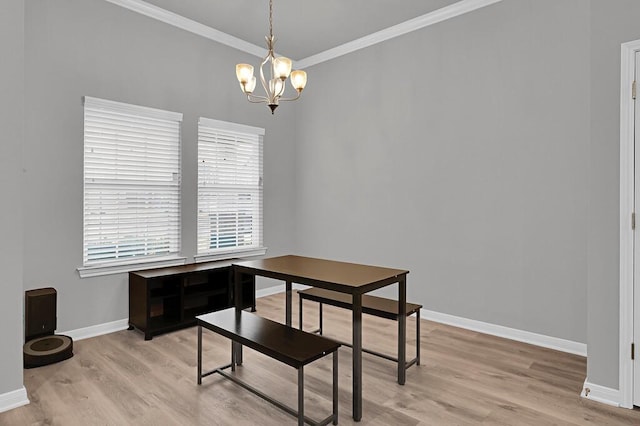 dining space featuring light wood-style floors, baseboards, a notable chandelier, and ornamental molding