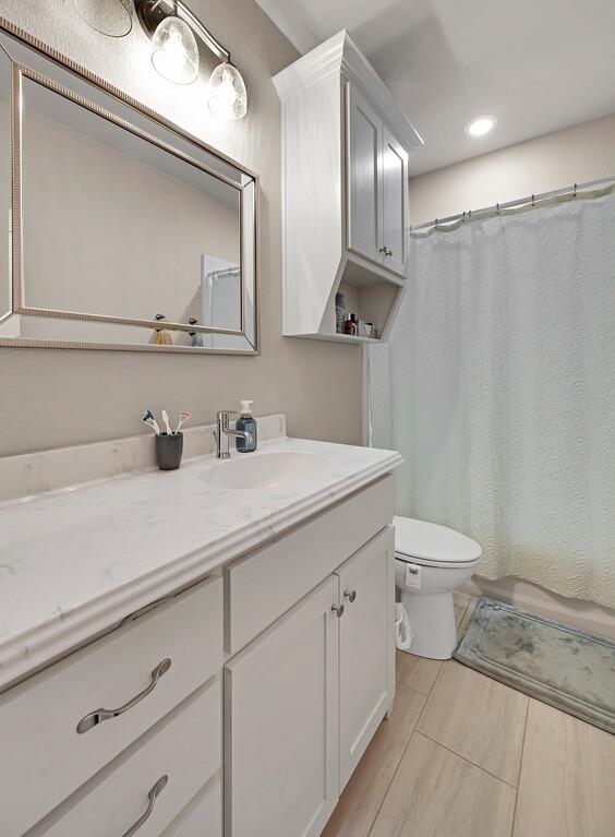 bathroom with toilet, vanity, and a shower with curtain