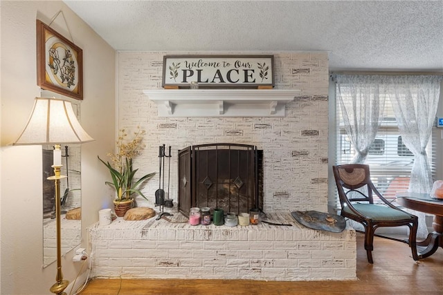 sitting room with a fireplace, hardwood / wood-style floors, a textured ceiling, and plenty of natural light