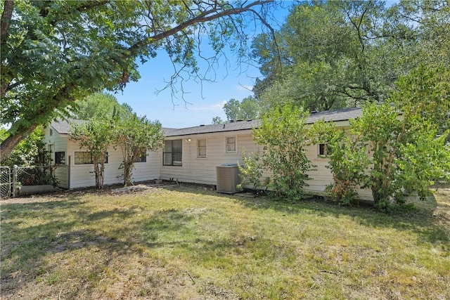 back of property with a lawn and central AC unit