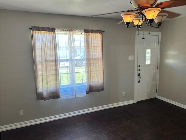 foyer featuring ceiling fan with notable chandelier and dark hardwood / wood-style floors