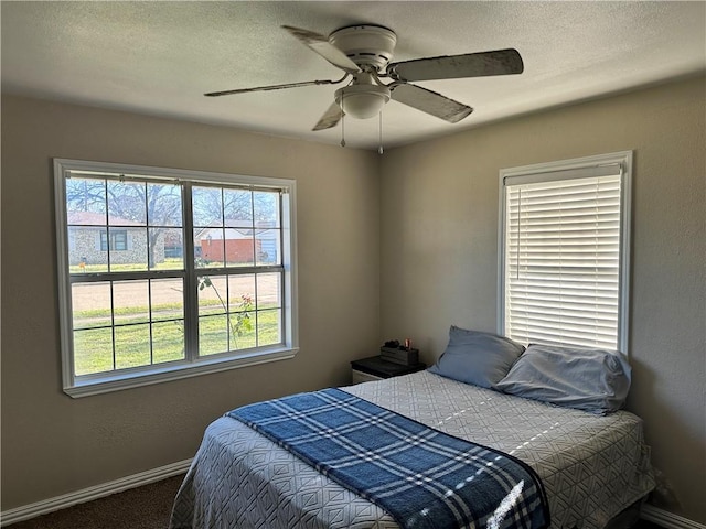 bedroom with ceiling fan and dark carpet