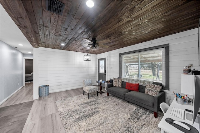 living room featuring ceiling fan, wood walls, wood ceiling, and light hardwood / wood-style flooring