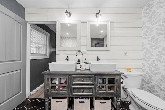 bathroom with toilet, vanity, wooden walls, and wood-type flooring