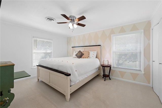 bedroom with ceiling fan, light colored carpet, and multiple windows