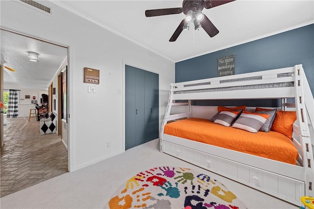 carpeted bedroom with ceiling fan and ornamental molding