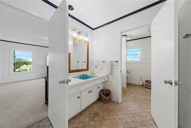 bathroom featuring a wealth of natural light, vanity, and tile walls