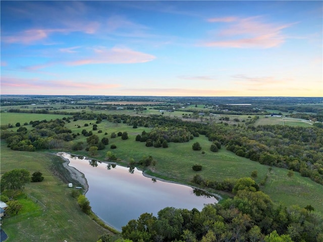 aerial view at dusk featuring a water view and a rural view