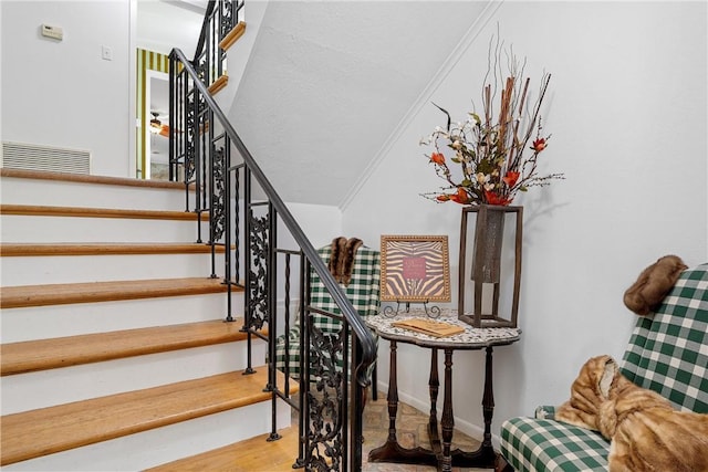 stairway with hardwood / wood-style floors and ornamental molding