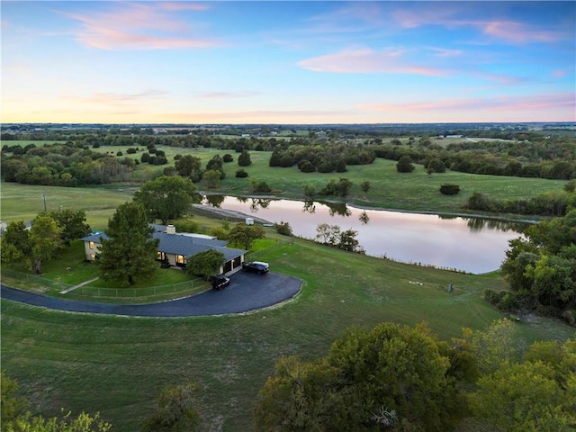 aerial view at dusk with a water view and a rural view