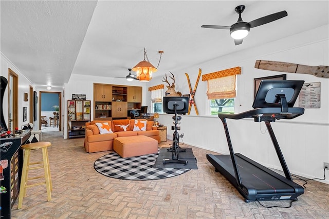 workout area featuring a textured ceiling and ceiling fan