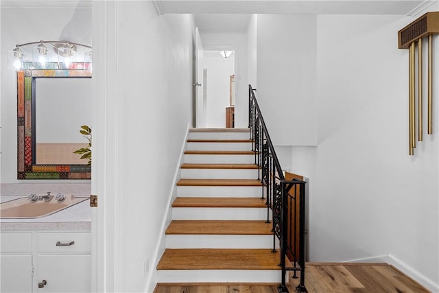 stairway featuring hardwood / wood-style floors and sink