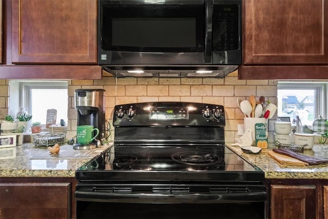 kitchen with electric range, light stone counters, and backsplash