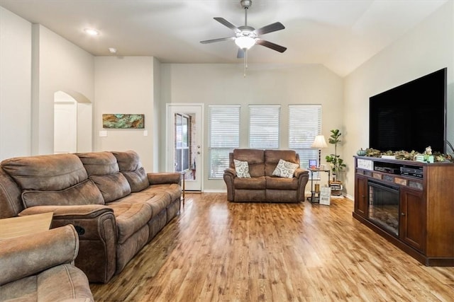 living room with ceiling fan, light wood-type flooring, and lofted ceiling