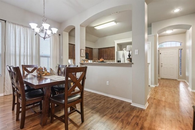 dining area featuring hardwood / wood-style floors, plenty of natural light, and a chandelier