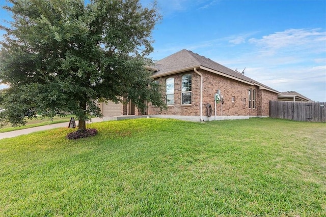 view of side of property featuring a garage and a lawn