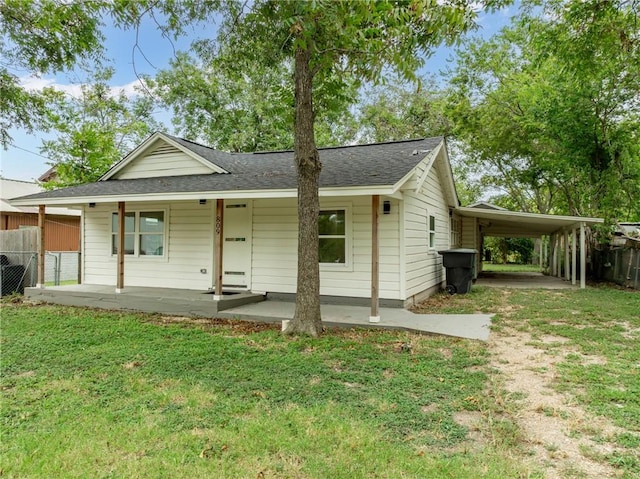 view of front facade with a carport, a porch, and a front lawn