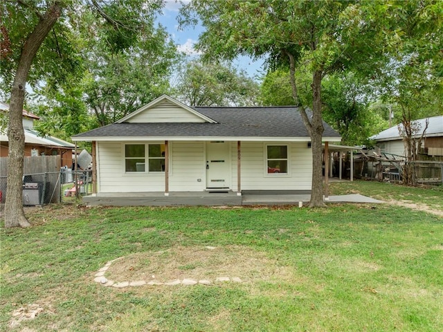 rear view of house featuring a lawn and a porch